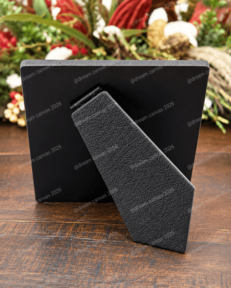 Back view of a black 5×5 Dream Canvas desktop plaque with angled built-in easel on a wooden table