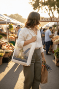 Cotton tote bag with Lantern and Quill art print carried at a farmers market